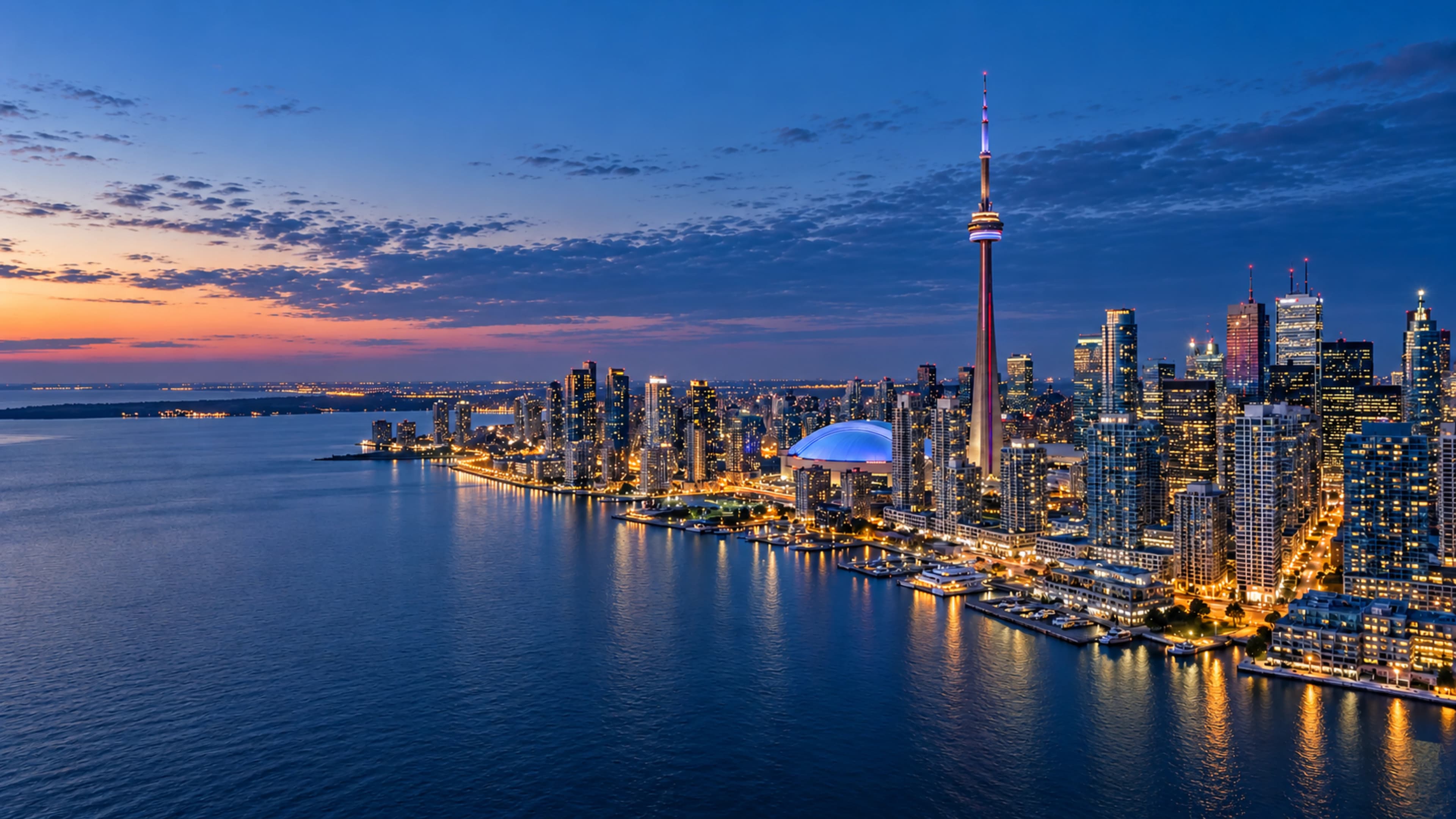 Toronto skyline and CN Tower beside Lake Ontario at blue hour